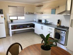 a kitchen with a table with a potted plant at Happy Valley Studio in Port Lincoln
