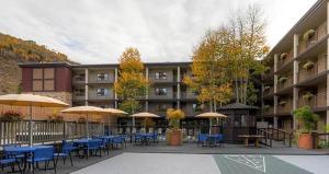 a courtyard with tables and chairs and umbrellas at Wren 201 Condo with Vail Mountain View in Vail +19 photos