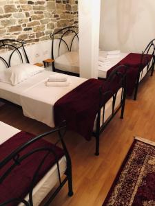 Un grupo de 4 camas en una habitación en Stone House Obelisk, en Gjirokastra
