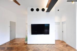 a living room with a tv on a white wall at Jerusalem of concrete&stell in Jerusalem