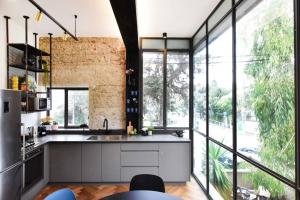 an open kitchen with large windows and a large kitchen island at Jerusalem of concrete&stell in Jerusalem