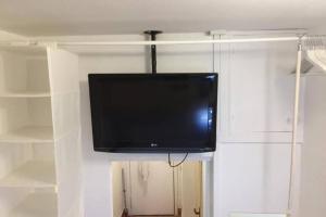 einen Flachbild-TV, der von einer Wand hängt in der Unterkunft Malavoglia Suite 18 in Aci Castello