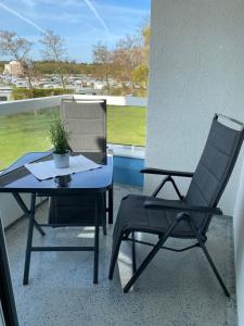 Duas cadeiras e uma mesa numa varanda em Studio Sam em Cuxhaven