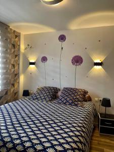 - une chambre avec un lit orné de fleurs violettes sur le mur dans l'établissement O'CEPAGES, à Ambonnay