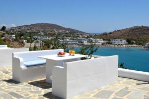 una mesa blanca y sillas en un patio con vistas al agua en Villa 9 Muses, en Vári