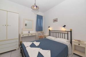 a bedroom with a bed and a dresser and a mirror at Villa 9 Muses in Vári