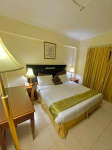 a hotel room with a large bed and a lamp at Al Nakheel Hotel Apartments in Dubai