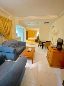 a living room with a couch and a table at Al Nakheel Hotel Apartments in Dubai