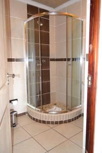 a shower with a glass door in a bathroom at Citystay West in Maseru
