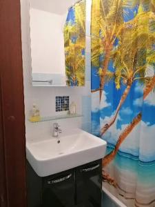 a bathroom with a sink and a palm tree shower curtain at CrisAnd 2 Bergen in Altenau