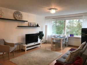 a living room with a tv and a table with chairs at Style studio in Lohja in Lohja