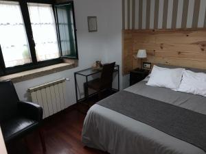ein Schlafzimmer mit einem Bett, einem Stuhl und einem Schreibtisch in der Unterkunft PARADA DE FRANCOS in Teo