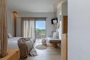 Habitación de hotel con cama y balcón en Evais Boutique Houses & Luxury Suites en Karistos