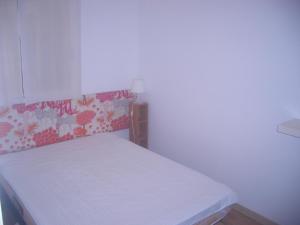 una piccola camera da letto con un letto con lenzuolo bianco di Acequion Beach Med Syndicate 9 a Torrevieja