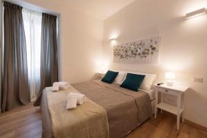 um quarto com 2 camas e almofadas verdes em Nel cuore di Orvieto em Orvieto