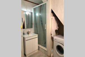 een badkamer met een wastafel en een wasmachine bij Maison dans village vacances in Portiragnes