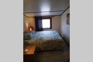 een kleine slaapkamer met een bed en een raam bij Maison dans village vacances in Portiragnes