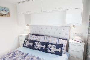 1 dormitorio con 1 cama con almohadas azules y blancas en Tony's Place with a breakwater view, en Plymouth