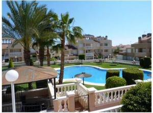 a view of a pool with palm trees and buildings at CASA BEDAMA in Orihuela Costa