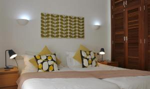 a bedroom with a bed with yellow and white pillows at Casa Amelia in Yaiza