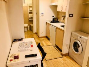 a small kitchen with a table and a washing machine at Appartamento Maggiore in Bologna