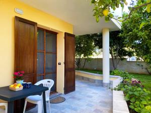 a patio with a table and chairs in front of a house at Domo sa Funtana in Olmedo +9 photos