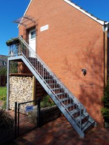 un escalier sur le côté d'un bâtiment en briques dans l'établissement Fewo Haus Morgenstern im Ankerweg, à Neuharlingersiel
