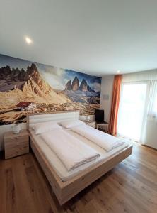1 dormitorio con 1 cama grande y un mural en la pared en Alpine Deluxe 2.0, en Riscone