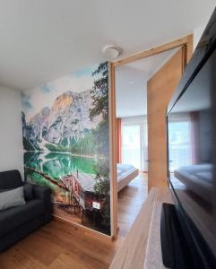 een woonkamer met een groot schilderij aan de muur bij Alpine Deluxe 2.0 in Riscone