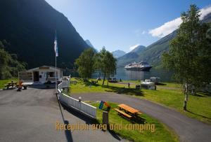a boat is docked at a recreation area and camping at Geirangerfjorden Feriesenter in Geiranger