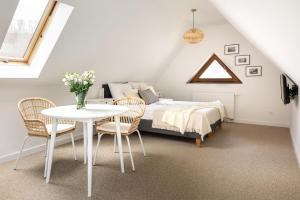 a bedroom with a bed and a table and chairs at Willa Perełka in Kudowa-Zdrój