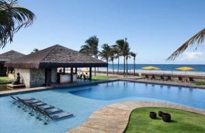 a swimming pool with a gazebo and the beach at Zorah Beach Hotel in Trairi