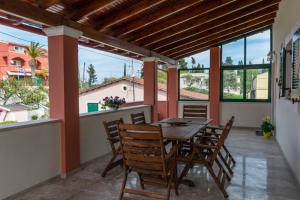 a dining room with a table and chairs on a balcony at Spiti Anna Maria in Corfu