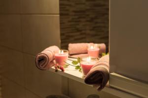 a bathroom mirror with candles and towels on a shelf at Spiti Anna Maria in Corfu