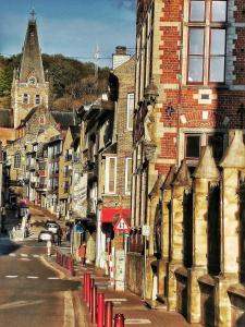 uma rua da cidade com edifícios e um edifício com uma torre do relógio em Huis Buizemont em Geraardsbergen