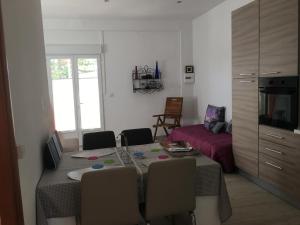 ein Wohnzimmer mit einem Esstisch mit Stühlen und einem Sofa in der Unterkunft La Villa BIANCA in Ragusa