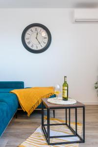 a table with a wine glass and a clock on the wall at Apartman Bonaca in Trogir