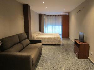 sala de estar con sofá y cama en Apartamentos Abastos, en Valencia
