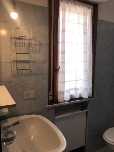 a bathroom with a sink and a toilet and a window at Villa Nadia in Grado