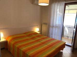a bedroom with a bed with a colorful striped blanket at Villa Nadia in Grado