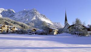 シェッファウ・アム・ヴィルデン・カイザーにあるFerienwohnung Steiner in Scheffauの雪山を背景に教会