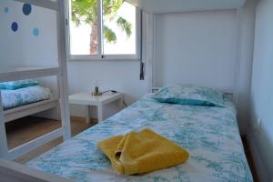 Un dormitorio con una cama con una toalla amarilla. en Sagres Natura, en Sagres