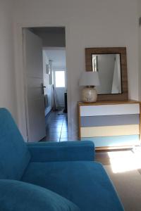 a living room with a blue couch and a mirror at Charmant Cabanon aux Goudes à Marseille avec vue mer in Marseille