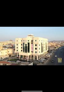 a large white building with a road in front of it at Al Wadaq Hotel in Taif