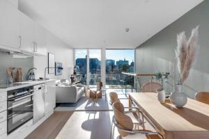 cocina y sala de estar con mesa y sillas en Awardwinning penthouse, Oslo city / Grünerløkka, en Oslo