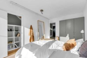 een slaapkamer met witte muren en een groot bed bij Awardwinning penthouse, Oslo city / Grünerløkka in Oslo