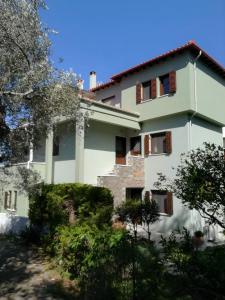 a large white house with trees in front of it at Almira Kalamos in Kálamos