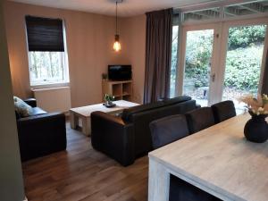 sala de estar con sofá y mesa en Bospark Nuwenspete, en Nunspeet