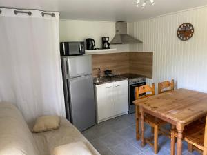 a kitchen with a wooden table and a kitchen with a refrigerator at Appartement dans Le Chalet in La Chapelle-en-Vercors