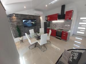 a kitchen with red cabinets and a table and chairs at Anita Prižba in Prizba